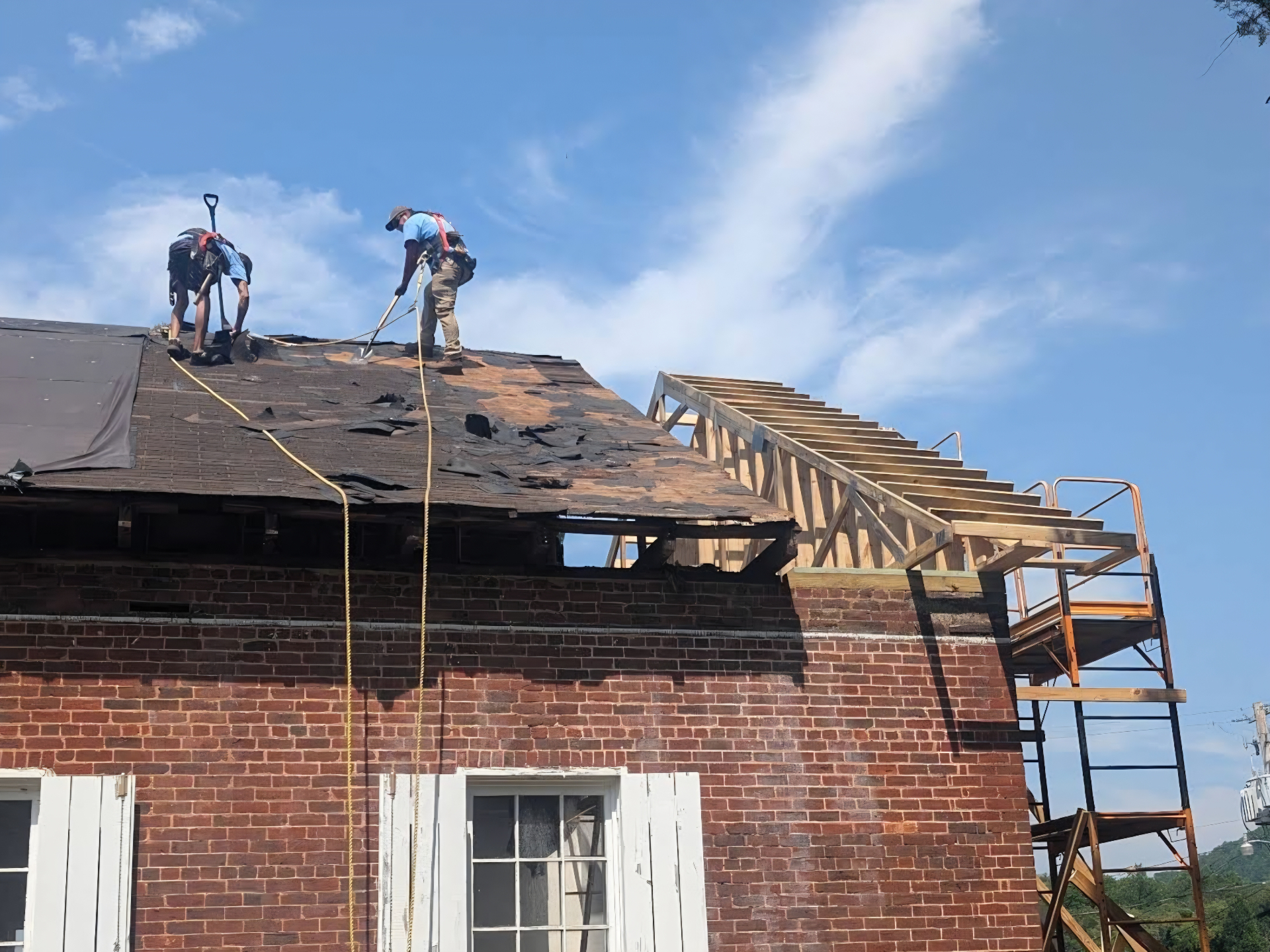 Roofing crew removing and replacing a roof on a brick building in Cherokee County NC by W's AllWorks general contractor